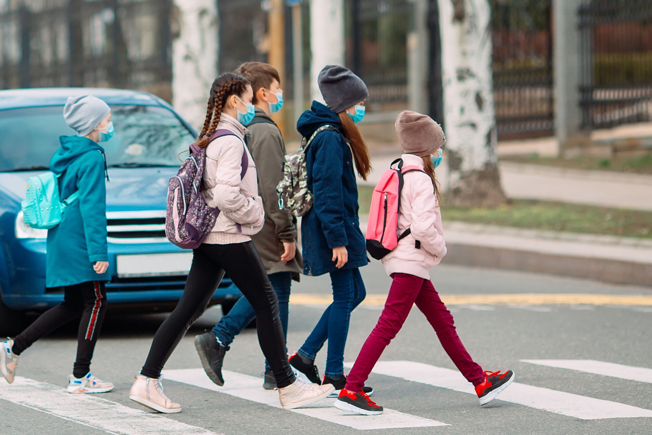School children cross the road in medical masks.